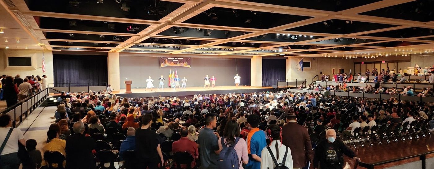 A large hall filled with seated attendees facing a stage during a regional conference