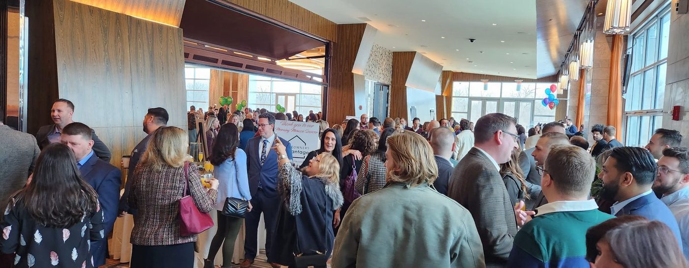 A crowded indoor reception with attendees standing in conversation